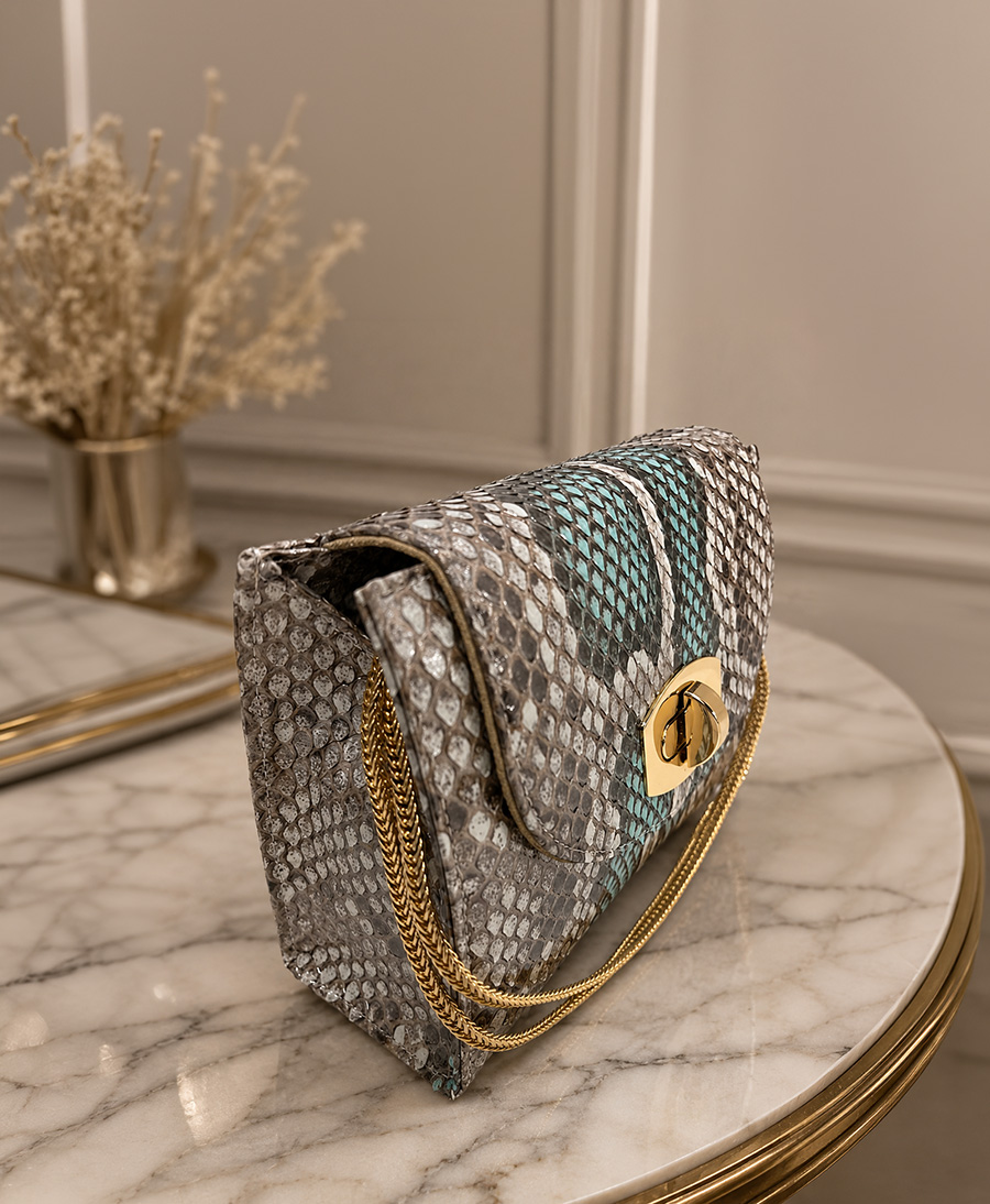Python skin chain clutch on marble